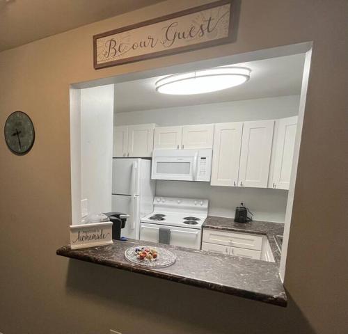 a kitchen with white cabinets and a plate on a counter at Cozy Retreat 1.8 Mi to Stadium in Gainesville