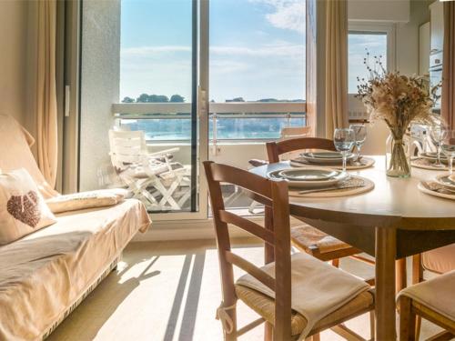 une salle à manger avec une table et une vue sur l'océan dans l'établissement Ploemeur Lomener T2 Balcon Vue Mer - FR-1-349-65, à Ploemeur