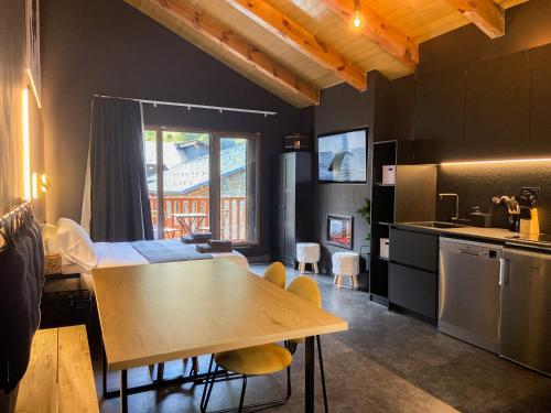 kuchnia i jadalnia ze stołem i krzesłami w obiekcie Modern Black Studio Penthouse En Valle De Incles - Parking Gratis w mieście Canillo