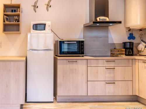 une cuisine avec un réfrigérateur et un micro-ondes dans l'établissement Studio rénové proche plages et bourg - Port-Louis, 2 pers., RDC, Wi-Fi, jardin commun - FR-1-349-108, à Port-Louis