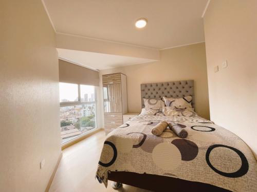 um quarto com uma cama grande e uma janela grande em Habitación privada con hermosa vista de Barranco em Lima