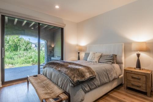 a bedroom with a bed and a large window at Creekhouse 1583 in Mammoth Lakes