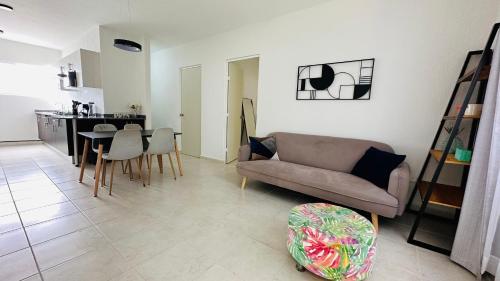 a living room with a couch and a table at Bonito departamento playa/planta baja in Playa del Carmen