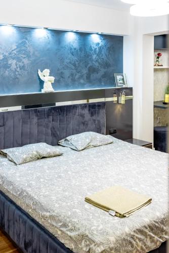 a bedroom with a large bed with a blue wall at Lady Suite in Cluj-Napoca