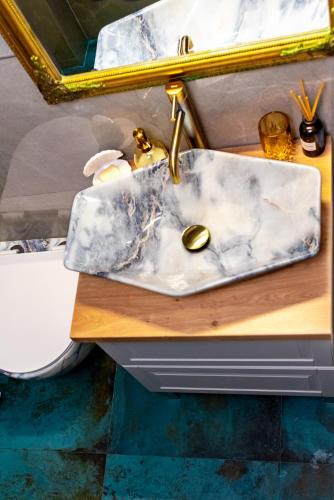 a bathroom sink with a gold faucet on a counter at Lady Suite in Cluj-Napoca