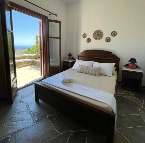 a bedroom with a large bed and a large window at Mirsini Apartments in Vathi