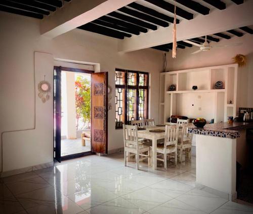een keuken en eetkamer met een tafel en stoelen bij Villa Euphoria - Adults Only in Paje