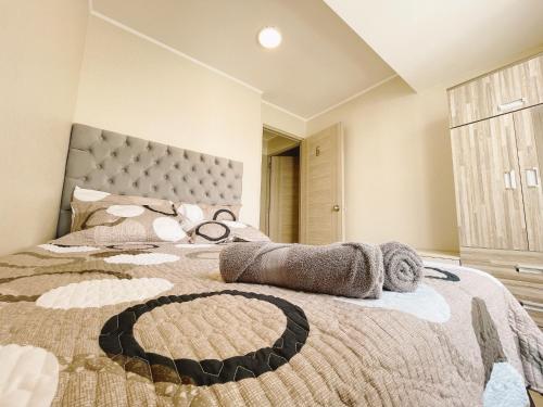 Un dormitorio con una cama grande con un cabecero grande. en Hermosa habitación privada en edificio de estreno frente al metro, en Lima