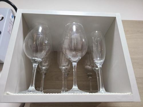 four empty wine glasses in a white box at Fantastic Beach condo with pool and mountain views in Nueva Gorgona
