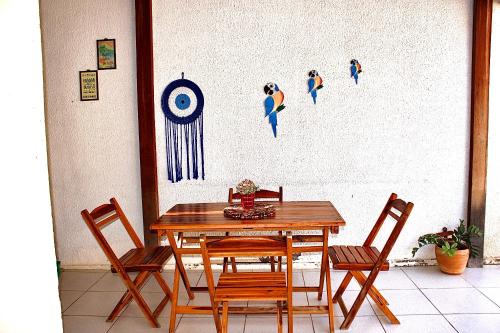a table and chairs with a wall with a target at Casa para Temporada Lençóis Ville in Barreirinhas