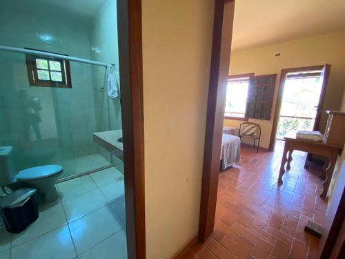 um quarto com casa de banho com banheira e um quarto em Casa dos Coqueiros - Cama, Café e Eventos em Itabirito
