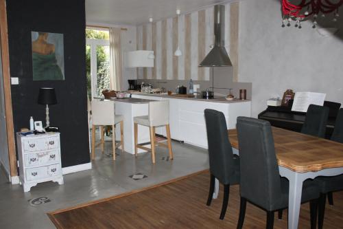una cucina e una sala da pranzo con tavolo e sedie di La Tropicale- Chambre d'hôte au calme a Nantes
