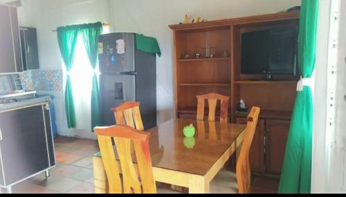 uma cozinha com uma mesa de madeira com cadeiras e um frigorífico em FINCA COOMPAB em El Peñol