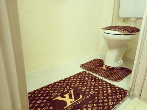 a bathroom with a toilet and a rug at Dream Villa in Ongata Rongai 