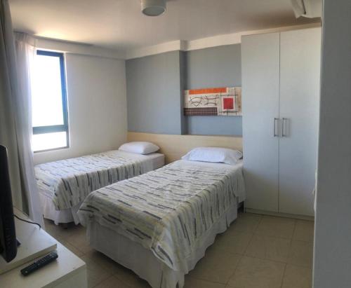 een kamer met 2 bedden en een televisie. bij 202 Flat frente Mar - Golden Tower in Natal