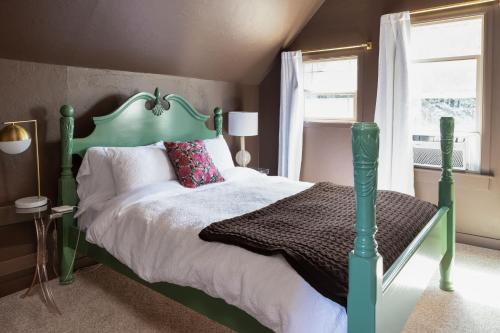 a bedroom with a green bed and a window at Wynkoop at Carlton: Taste of Europe, Walk to Wineries, Dog Friendly in Carlton
