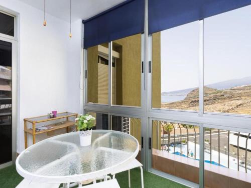 TabaibaにあるLive Tabaiba Decre con piscinaのガラステーブルと大きな窓が備わる客室です。
