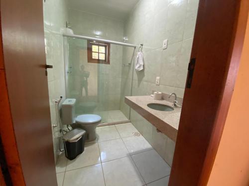 a bathroom with a toilet and a sink and a shower at Hospedaria Casa dos Coqueiros in Itabirito