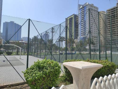 un parque con una valla y un banco delante en Live Like A Family Home Away From Home, en Sharjah