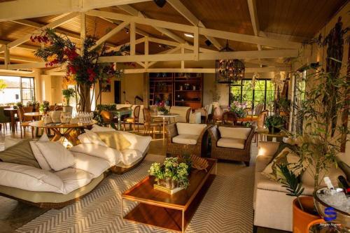 a large living room with white couches and tables at Casa do Valle - Hotel Boutique in Chapada dos Guimarães