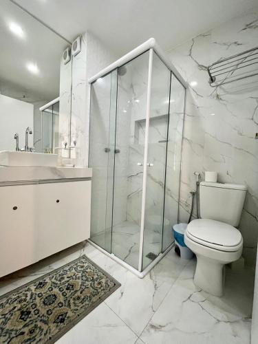 a white bathroom with a toilet and a shower at Beira a mar Ponta Negra Beach, Lovely Flat Natal RN in Natal