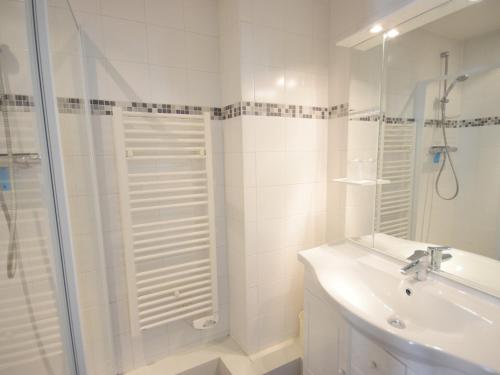 uma casa de banho branca com um chuveiro e um lavatório. em Appartement Évian-les-Bains, 2 pièces, 4 personnes - FR-1-498-14 em Évian-les-Bains