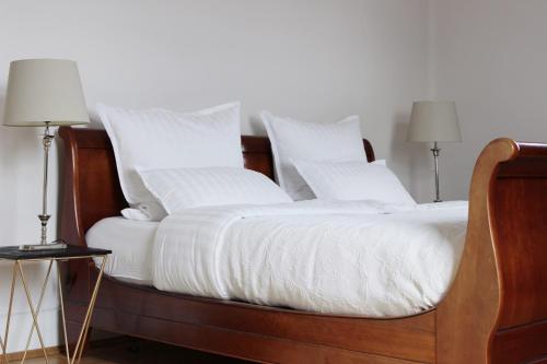 uma cama com lençóis brancos e almofadas em Wunderschöne, großzügige Wohnung em Bad Soden am Taunus