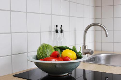 a bowl of vegetables sitting on a counter next to a sink at Wunderschöne, großzügige Wohnung in Bad Soden am Taunus