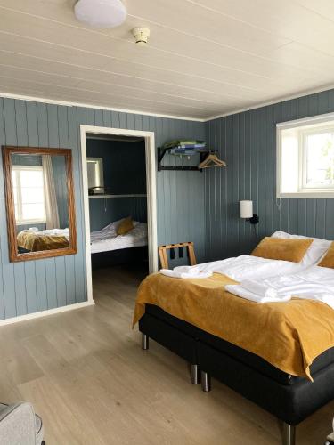 a bedroom with a large bed and a mirror at Vega Havhotell in Vika