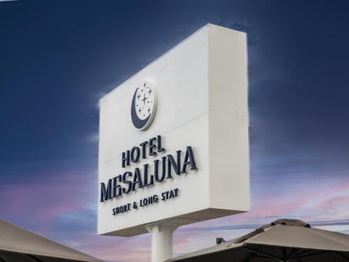 a sign for a hotel mitziana with a clock on it at Hotel Mesaluna Short & Long Stay in Ciudad Juárez