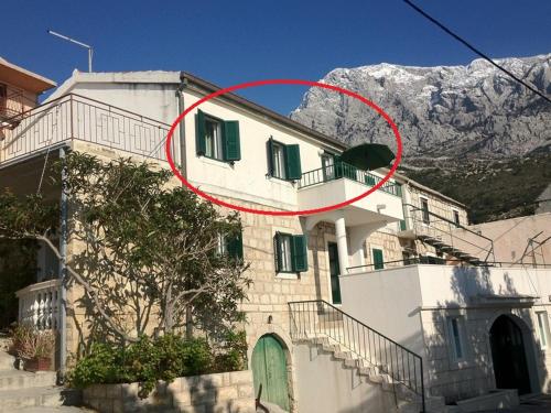 a house with a red circle in front of it at Apartment Ana Bratus in Baška Voda