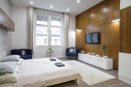 een slaapkamer met een bed en een tv aan de muur bij CCC Apartments in Boedapest