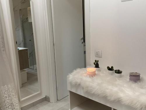 a bathroom with a white counter with plants and a mirror at Pash room in Pero