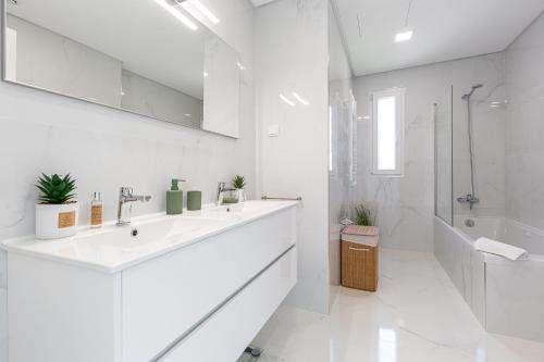 a white bathroom with a sink and a shower at SIHEM ‘S Villa Luxury House in Santa Barbara