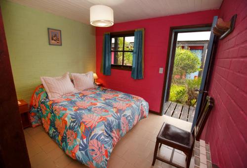 a bedroom with a bed and a red wall at Lago Argentino Hostel in El Calafate