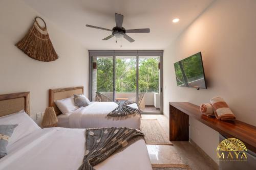 een slaapkamer met 2 bedden en een plafondventilator bij Exclusive condominium with pool in Tulum