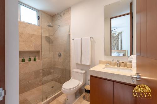 een badkamer met een douche, een toilet en een wastafel bij Exclusive condominium with pool in Tulum