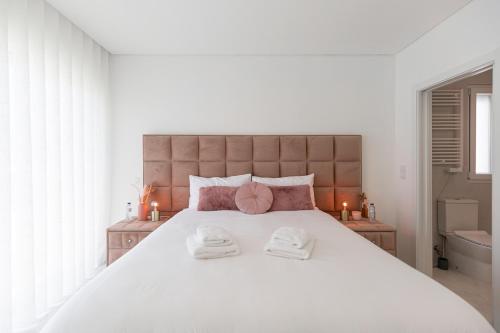 a bedroom with a large white bed with two towels at SIHEM ‘S Villa Luxury House in Santa Barbara