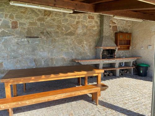 a stone kitchen with benches and a stove at Casa das Portelas in Ponte de Lima