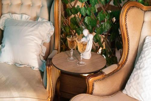 un tavolo con due bicchieri di champagne su una sedia di Reina Spa a Sarajevo