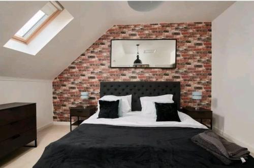 een slaapkamer met een bakstenen muur en een bed bij Lawnswood Place in Manchester
