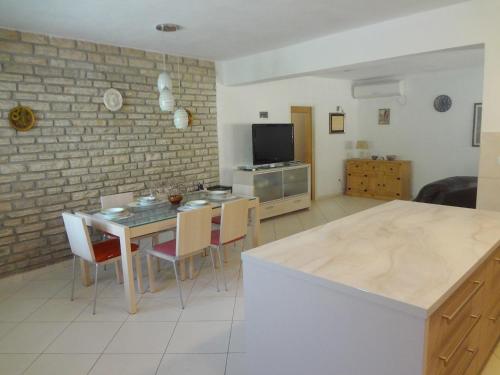 cocina y sala de estar con mesa y sillas en Villa Dijana en Prvić Šepurine