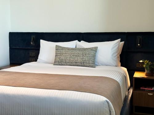 a bedroom with a large bed with white pillows at Wyndham Quito Airport in Tababela