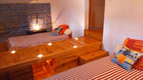 um quarto com 2 camas e uma cama de madeira em Chez Suzon em Auzon