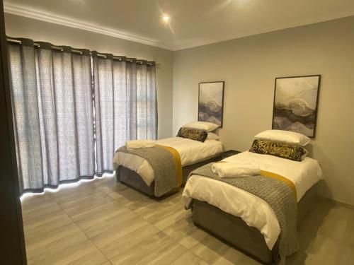 a bedroom with two beds and a window at 2968@Kingfisher in Parys