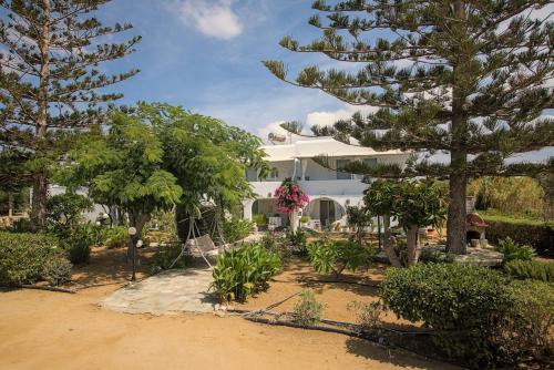 a large white house with trees in front of it at Maroussa Studios in Agia Anna Naxos