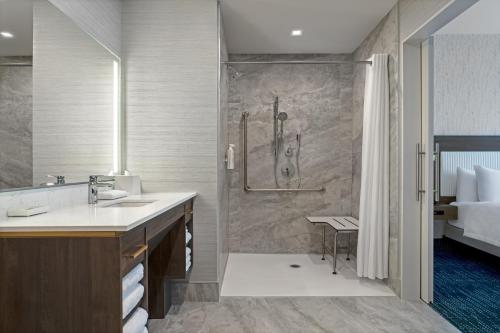 uma casa de banho com um chuveiro e um lavatório. em Home2 Suites By Hilton Huntsville em Huntsville