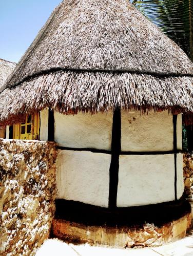 a thatch roofed house with a thatched roof at Hotel y Museo Aldea Maya Toktli Orígenes - Suite Casa Maya 3 Culturas - Alberca, Wifi Starlink, Tour Museo in Izamal