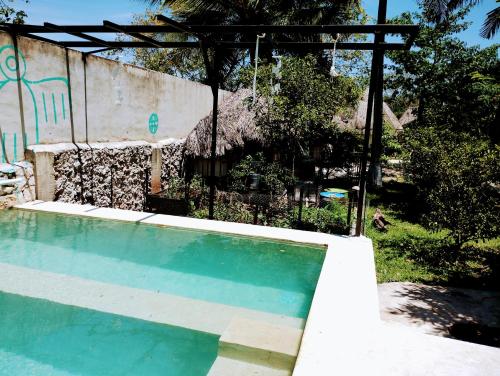 a swimming pool in front of a building at Hotel y Museo Aldea Maya Toktli Orígenes - Suite Casa Maya 3 Culturas - Alberca, Wifi Starlink, Tour Museo in Izamal