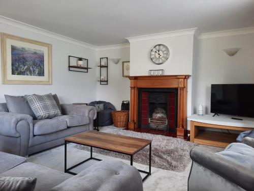 a living room with couches and a fireplace at 3 Brookside House in Pickering